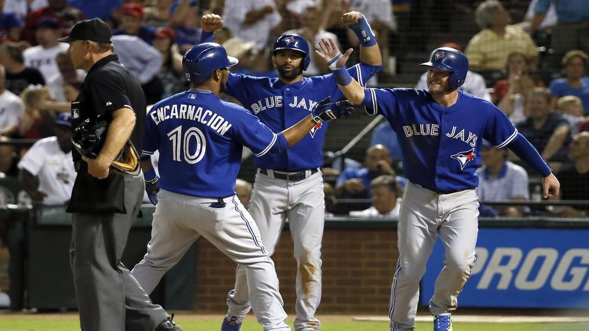 
Home plate umpire Ed Hickox stands by the plate as Blue Jays slugger Edwin Encarnacion, left, is congratulated by Jose Bautista, center, and Josh Donaldson, right, following Incarnation’s grand slam in the sixth inning Wednesday at Globe Life Park. Texas lost 12-4.

