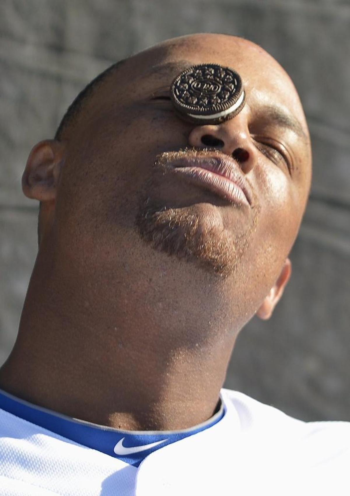 Rangers third baseman Adrian Beltre tries to, unsuccessfully, guide a cookie down his face and into his mouth without the use of this hands during the taping of a bit for the Texas Rangers ballpark video screens during spring training.