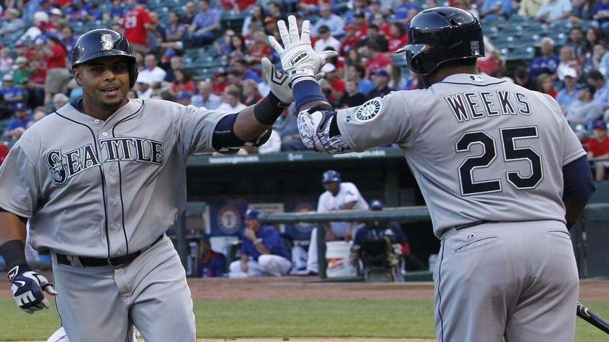 
Seattle Mariners designated hitter Nelson Cruz gets a high five from teammate Rickie Weeks after Cruz's mammoth home run in the second inning. 
