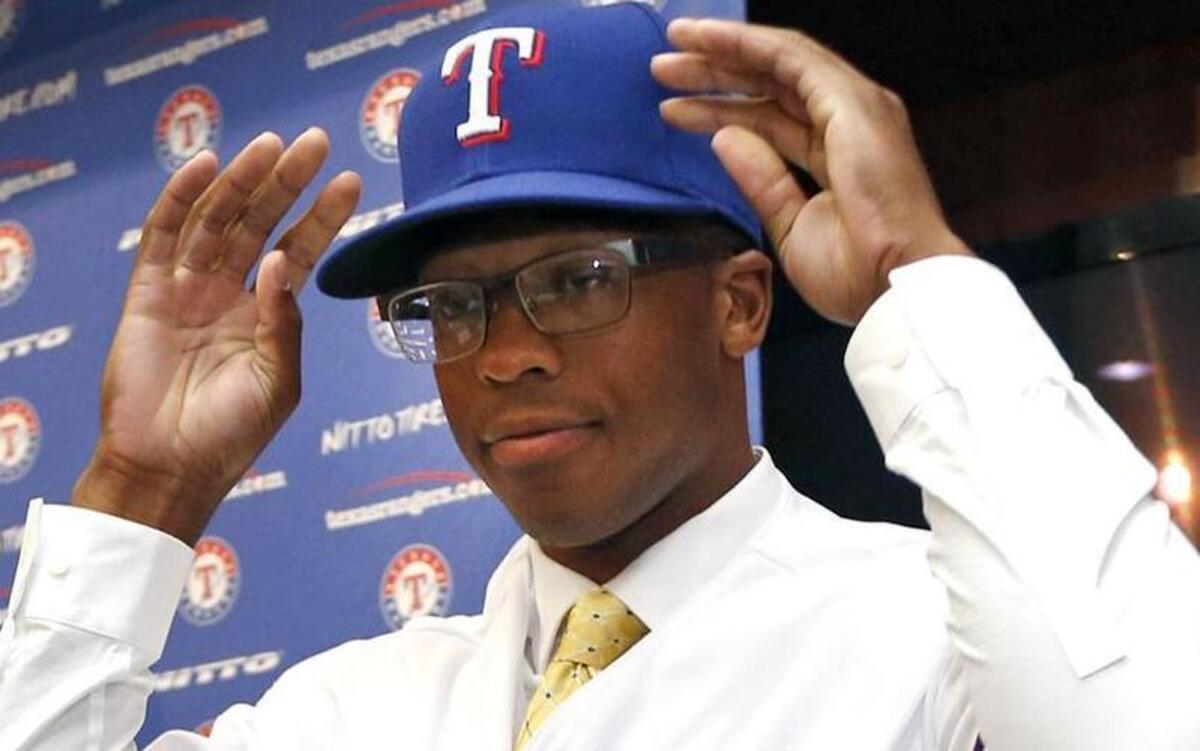 
Texas Rangers first-round draft selection Dillon Tate tries on a Rangers jersey and cap during a news conference Friday, June 12, 2015, in Arlington, Texas. 
