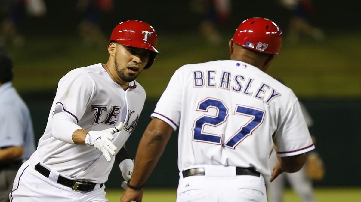 
Rangers’ catcher Robinson Chirinos is congratulated by third base coach Tony Beasley after his homer in the third inning Wednesday against the Tigers.

