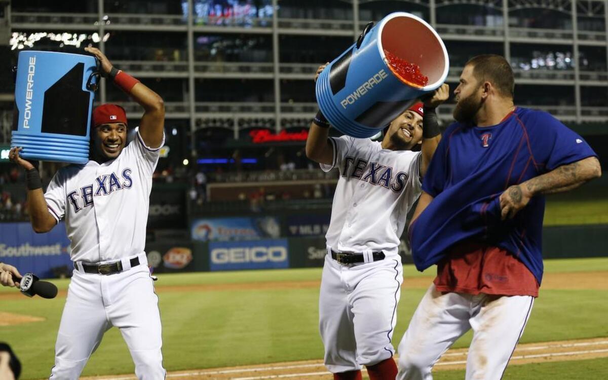 
Rangers’ outfielder Mike Napoli, right, runs away from Elvis Andrus, left, and Rougned Odor, who are trying to douse him after Texas’ 6-2 win over the Tigers Wednesday night at Globe Life Park.
