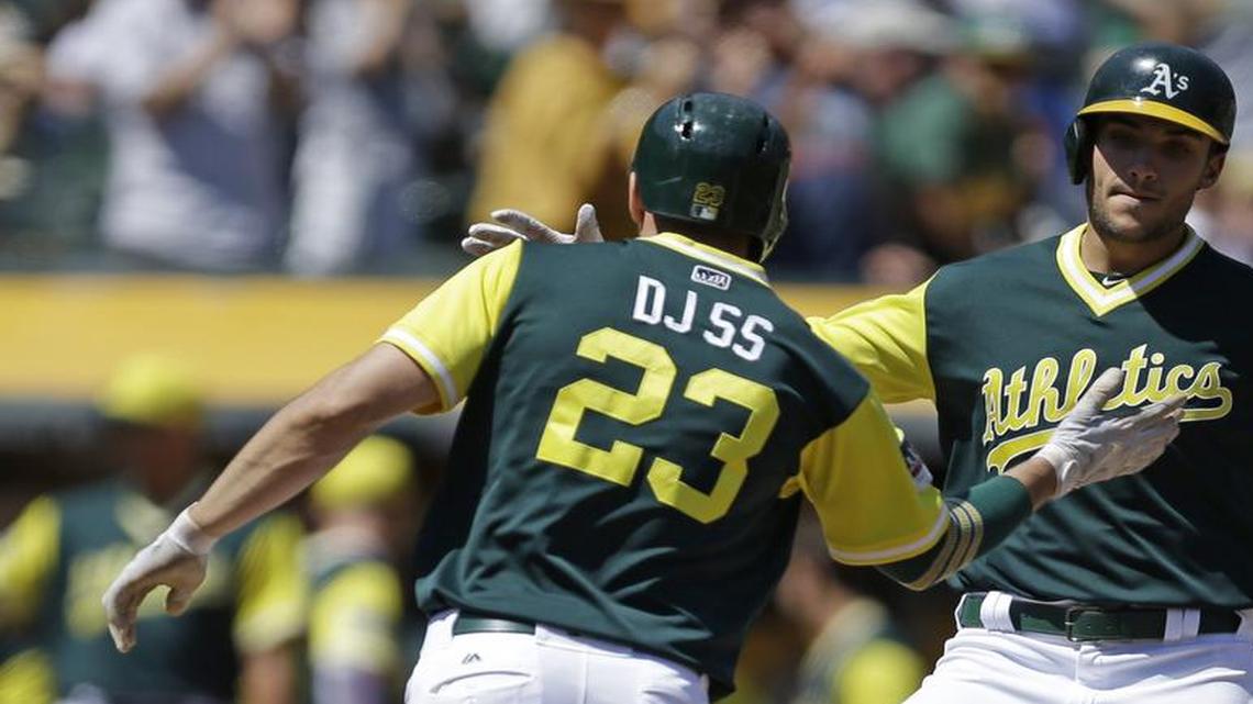 Matt Olson, right, celebrates with Matt Joyce after hitting a two-run home run off A.J. Griffin in the second inning Sunday.