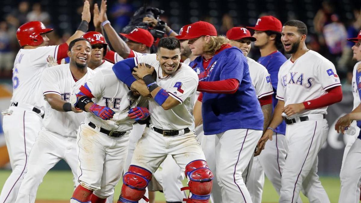 Robinson Chirinos grabs Rougned Odor in a headlock as the Rangers celebrate Tuesday night’s walk-off victory. Texas improved to 27-8 in one-run games.