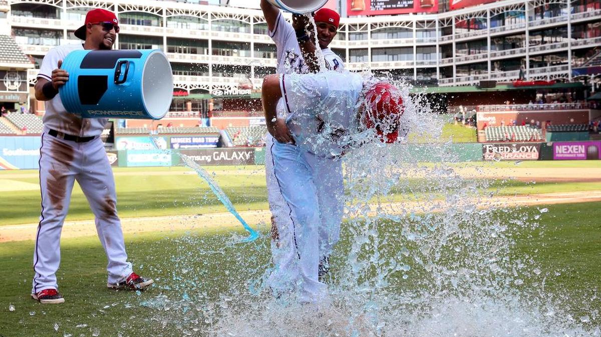 
Texas Rangers Rougned Odor (12) and Elvis Andrus (1) give Ryan Strausborger (20) a powerade bath after the 5-3 win over the Tampa Bay Rays at Globe Life Park Sunday.
