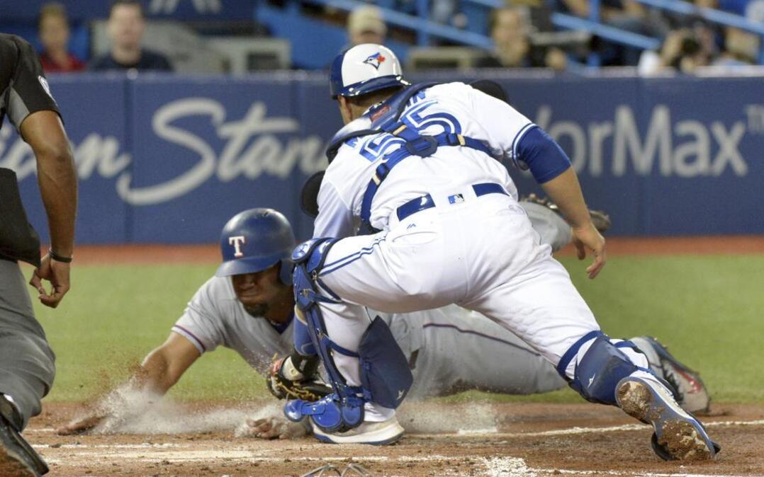 Elvis Andrus, left, was thrown out at home in the third inning Friday night after he failed to stop at third base despite a late stop sign by third base coach Tony Beasley.