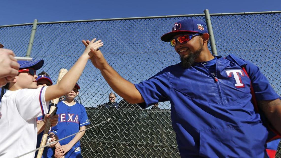 Rangers second baseman Rougned Odor, right, slaps hands with a young fan during spring training in Surprise, Arizona last February.