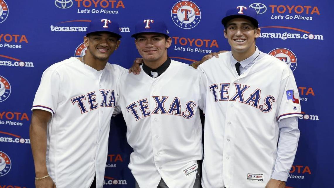The Rangers’ top three draft picks last year, Bubba Thompson, left, Chris Seise and Hans Crouse, right, pose together after a news conference announcing they had signed with the club on June 16.