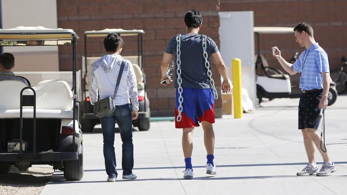 Rangers pitcher Yu Darvish carries two heavy chains to add to his workout during Monday’s spring training session in Surprise, Ariz.
