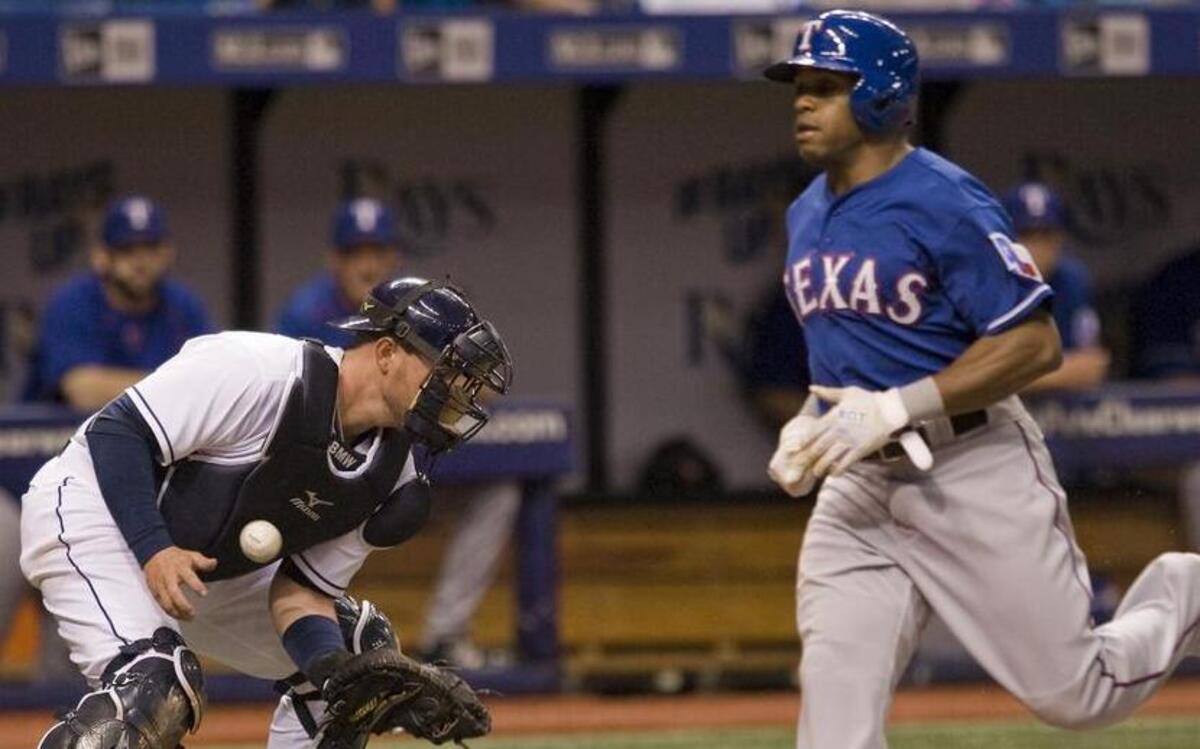 
Tampa Bay Rays catcher Bobby Wilson bobbles a wide throw to the plate as the Texas Rangers’ Delino DeShields scores on Elvis Andrus’ two-run single during the second inning.
