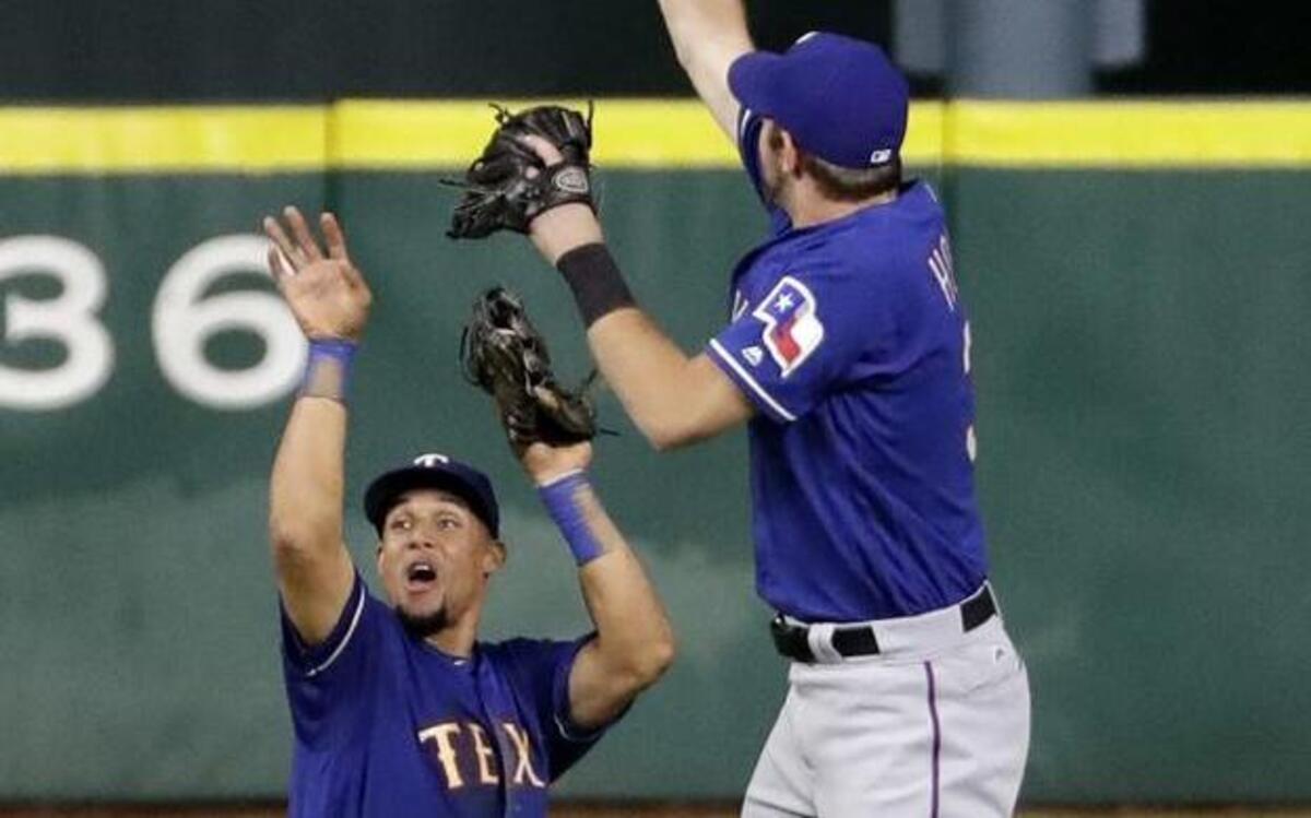 Before celebrating a 3-2 win with Jared Hoying, right, Carlos Gomez had to avoid a lime thrown by a fan to make the final out Tuesday.