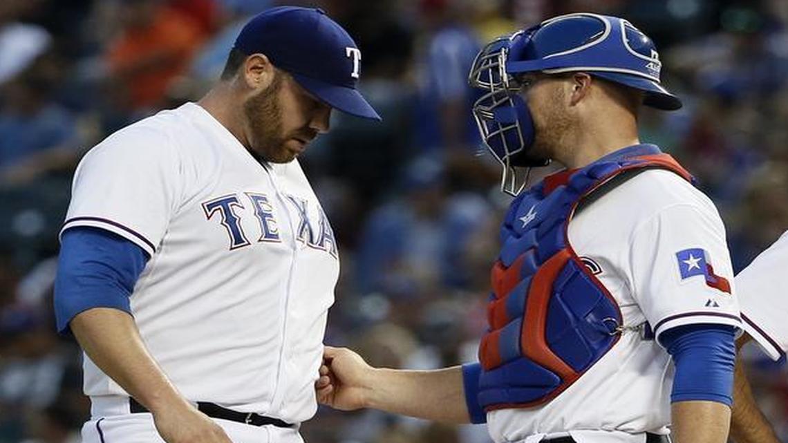 
Texas Rangers' Colby Lewis, left, talks with catcher Chris Gimenez, second from left, as Rangers pitching coach Mike Maddux and umpire Ed Hickox, right, walk off the mound during the third inning of a baseball game against the Toronto Blue Jays on Wednesday, Aug. 26, 2015, in Arlington, Texas.
