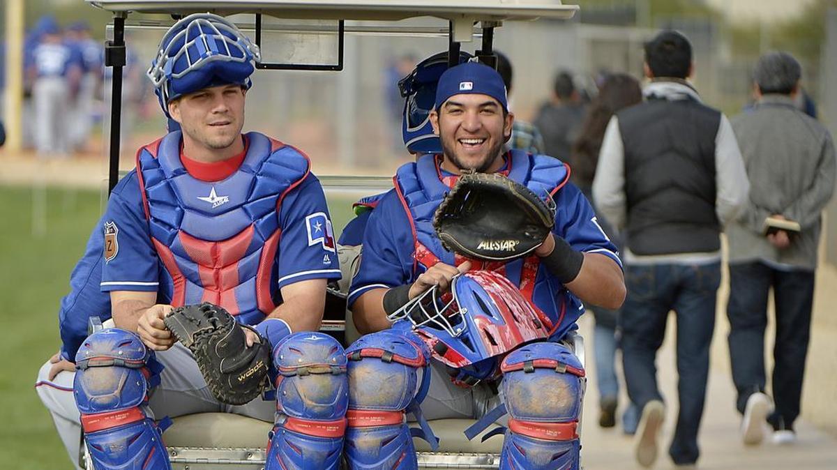 Texas Rangers catchers Patrick Cantwell, left, and catcher Jose Trevino get golf cart rides to the bullpen at spring training in Surprise, Ariz., in February. Trevino was one of six players added to the 40-man roster on Monday.