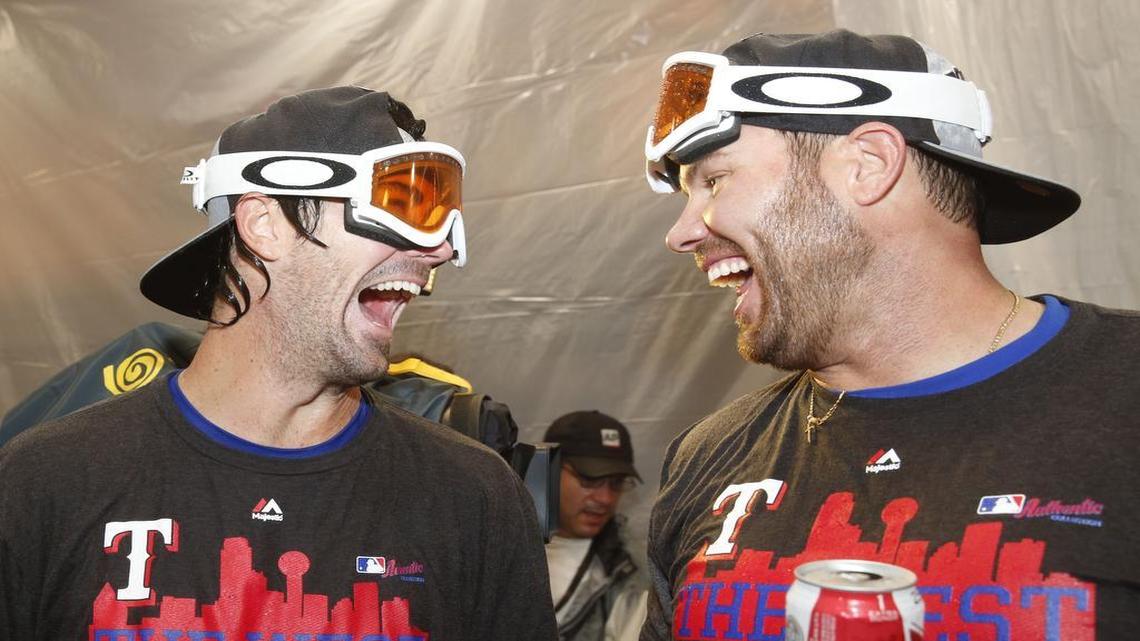 Rangers’ pitchers Cole Hamels, left, and Colby Lewis celebrate American League West title in the clubhouse on October 4.