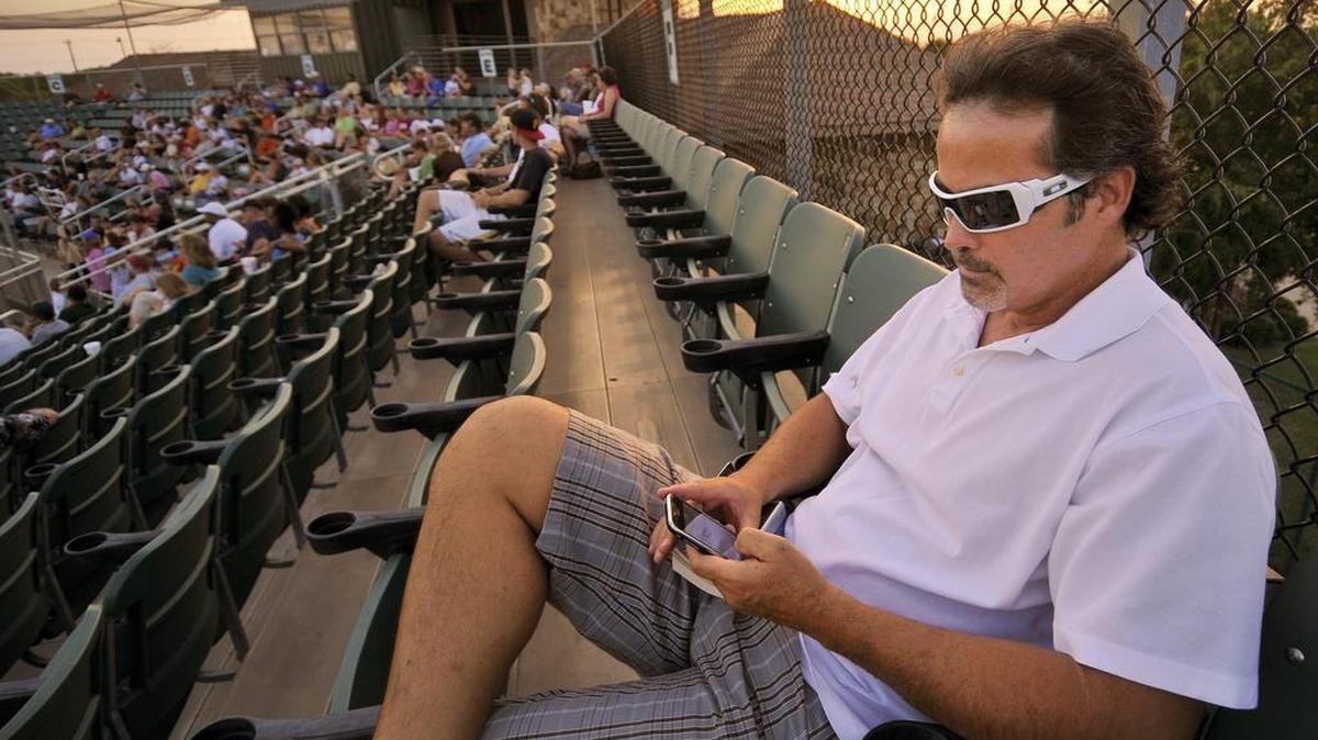 Former Rangers great Rafael Palmeiro watching a video of his son’s at bat during Patrick’s summer league team, the McKinney Marshals in 2010.