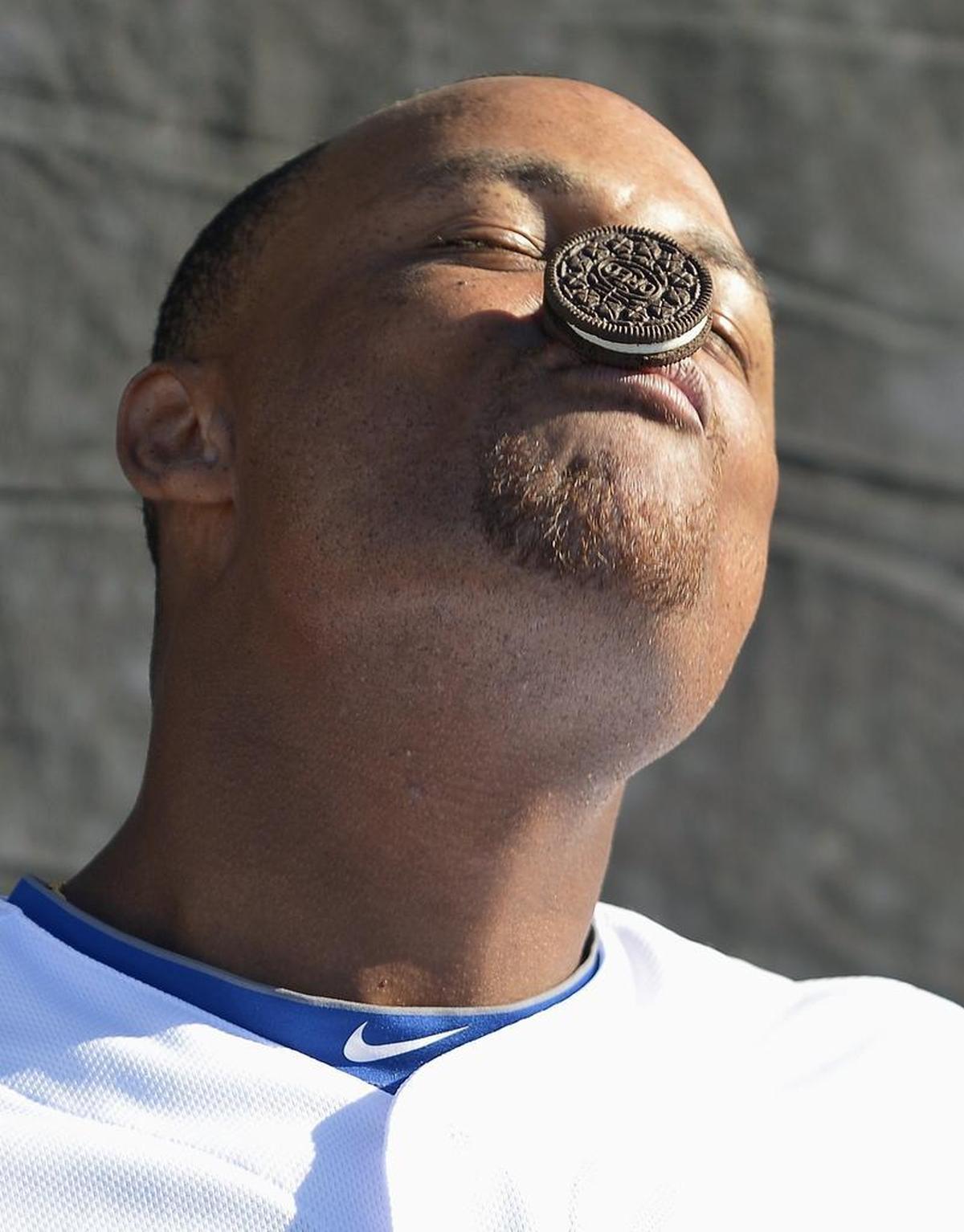 Rangers third baseman Adrian Beltre tries to, unsuccessfully, guide a cookie down his face and into his mouth without the use of this hands during the taping of a bit for the Texas Rangers ballpark video screens during spring training.
