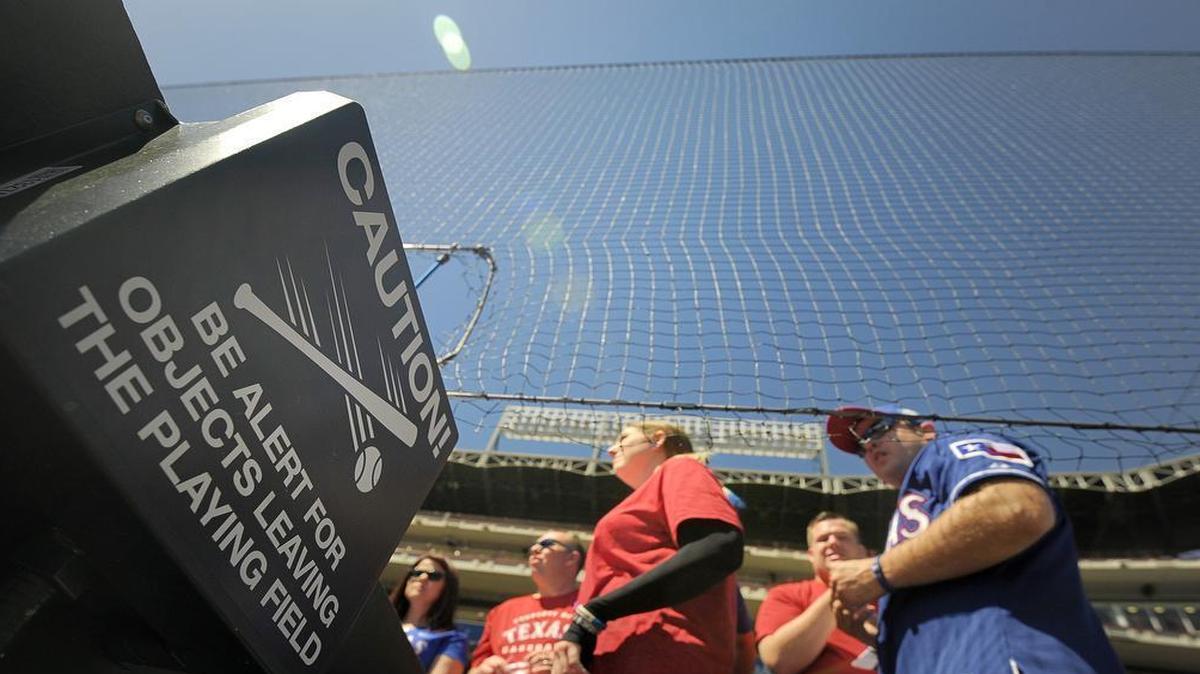 Before Monday’s opener, Rangers fans stand behind new safety nets that rise six feet above both dugouts