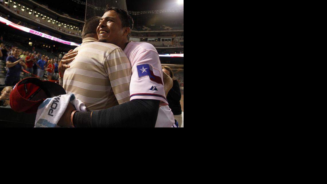 
Rangers shortstop Guilder Rodriguez hugs his father Guillermo after making his major league debut last September. He had played in 1,095 minor league games before getting his first call up. Texas announced that he and seven others had signed minor league deals for 2015.
