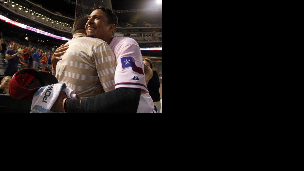 
Rangers shortstop Guilder Rodriguez hugs his father Guillermo after making his major league debut last September. He had played in 1,095 minor league games before getting his first call up. Texas announced that he and seven others had signed minor league deals for 2015.
