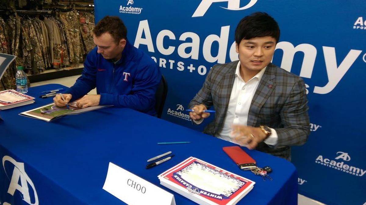Rangers players Shin-Soo Choo, right, and Sam Dyson, signed autographs at a winter caravan appearance in North Fort Worth Sunday afternoon.