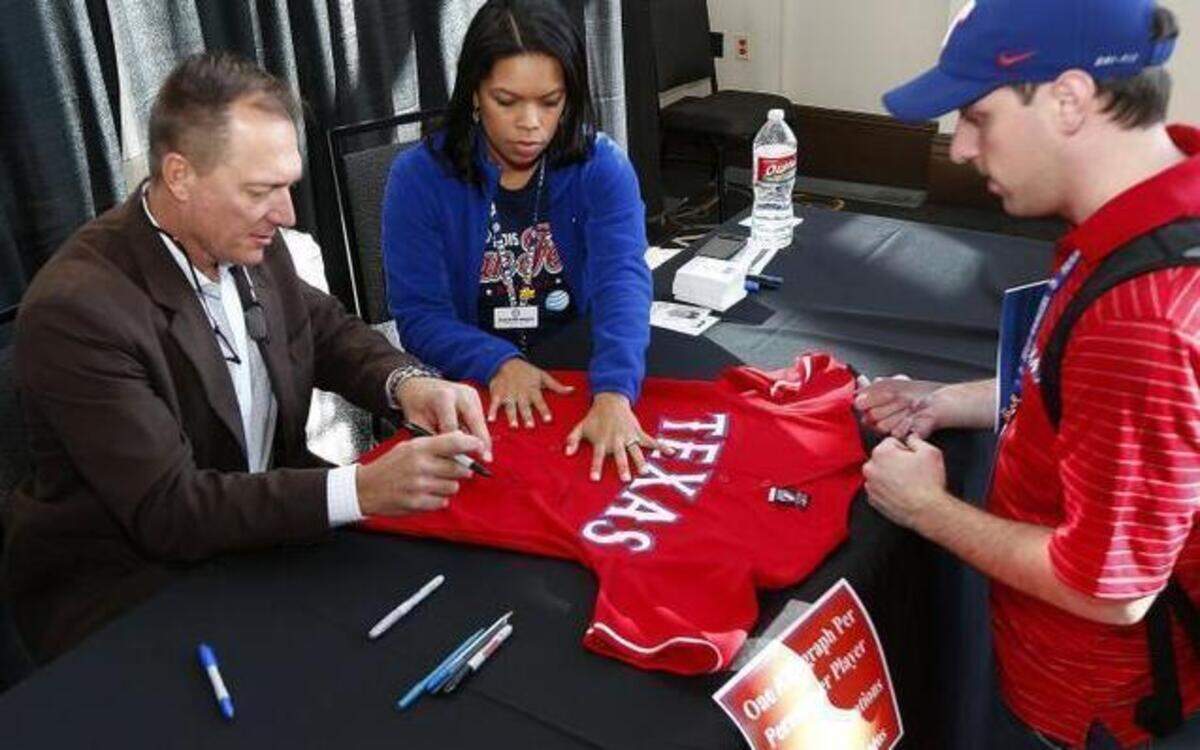 
Rangers manager Jeff Banister, left, signs a jersey for Andrew Barnes, of McKinney, at Saturday’s Fan Fest.
