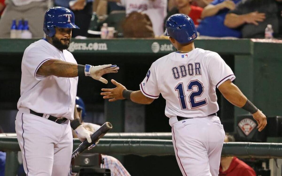 
Rangers second baseman Rougned Odor arriving in the dugout, slaps five with Prince Fielder, after scoring on a sacrifice fly by Leonys Martin in the seventh Friday.
