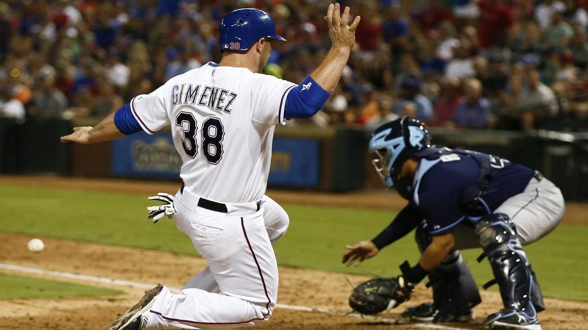 Chris Gimenez, sliding into home during a game in August, signed a one-year split contract for $975,000, avoiding arbitration and giving the Rangers valuable catching depth and experience.