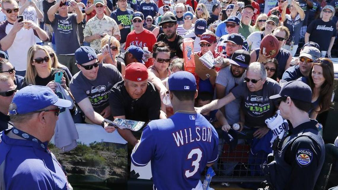 Russell Wilson signs autographs during a visit to Texas Rangers spring training in March 2014.
