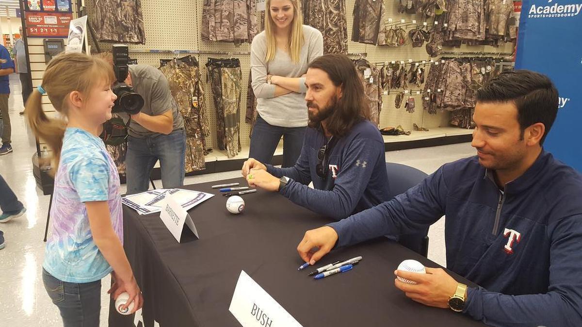 Tony Barnette, left, and Matt Bush sign autographs during a stop on the Texas Rangers Winter Caravan in January 2017.