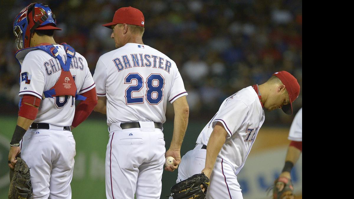 
Texas Rangers manager Jeff Banister pulls pitcher Wandy Rodriguez, right, after he gave up a grand slam in the third inning against the New York Yankees Tuesday at Globe Life Park.
