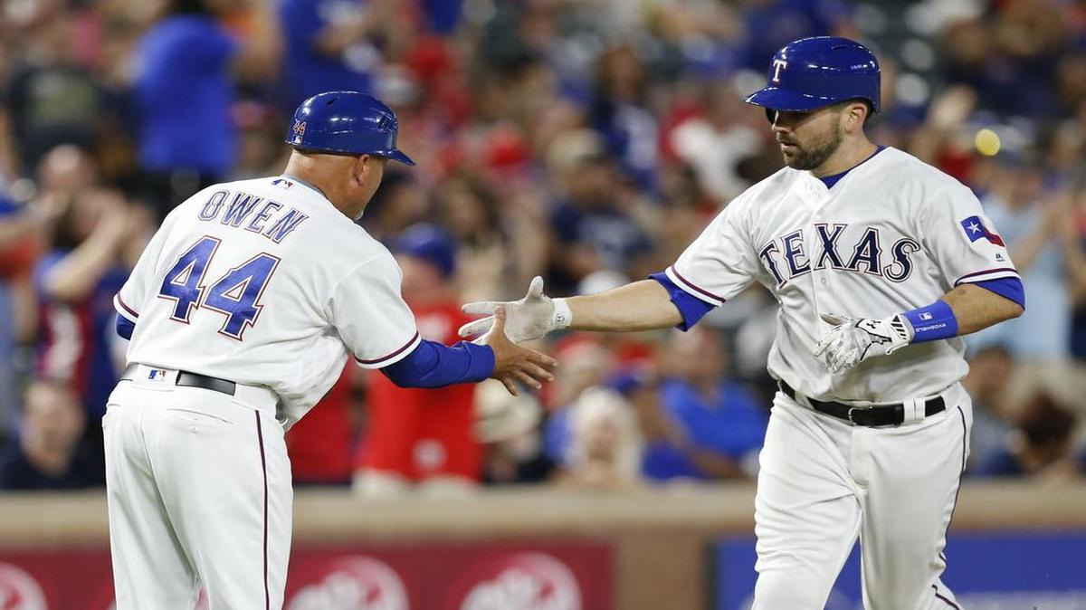 Brett Nicholas, right, celebrates a home run with third base coach Spike Owen in April. Nicholas played in 10 games during the Rangers’ first month before returning to Triple A Round Rock. Nicholas is likely to be one of several players called up to the majors Friday.