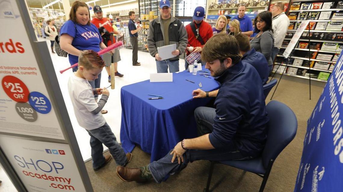 Haygen Hernandez, age 6, compares boots with Mitch Moreland after getting his autograph as Moreland and Shawn Tolleson appear at the Rangers’ first Winter Caravan stop in January 2014.