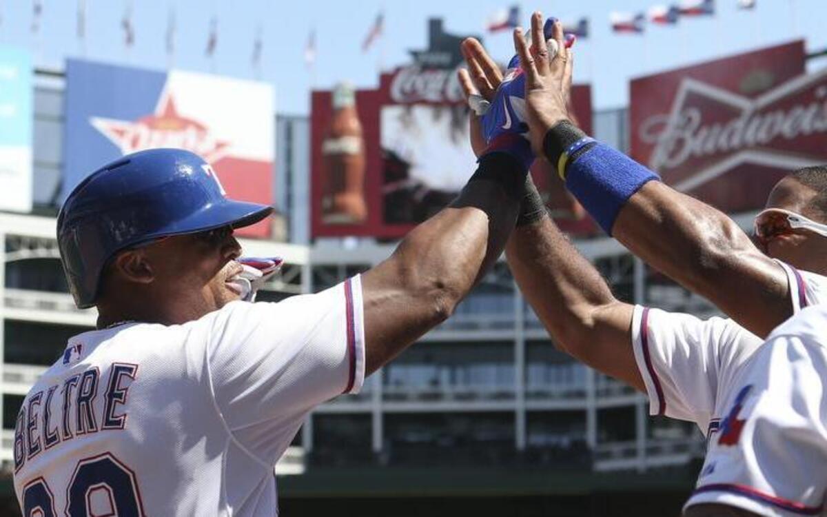 
Adrian Beltre, left, receives high-fives from his Rangers teammates in the fourth inning Sunday after hitting a two-run homer.
