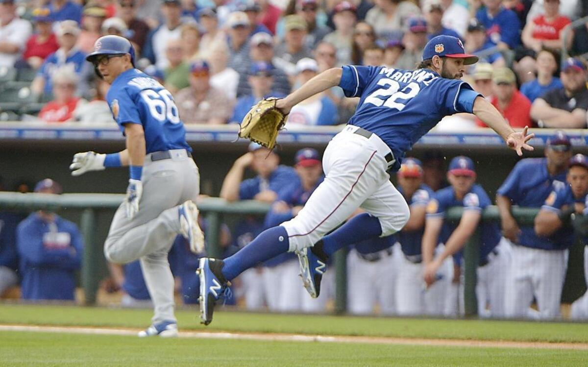 Rangers starting pitcher Nick Martinez fields a bunt hit Cubs shortstop Munenori Kawasaki and gets the runner out at home in the second inning Sunday at Surprise Stadium.