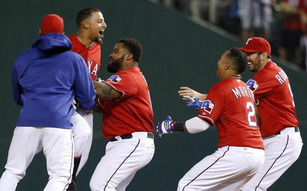 
The Rangers celebrate after Rougned Odor, second from left, hit the game-winning RBI single in the 10th inning Saturday night.


