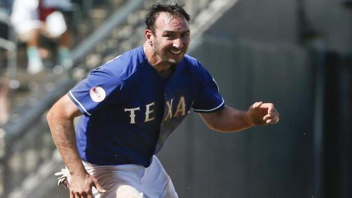 
The Rangers’ Adam Rosales starts for home after a throw to third went down the left field line. Los Angeles Angels third baseman David Freese was hurt during the play in the sixth inning Tuesday in Surprise, Ariz.
