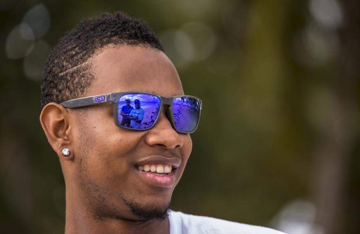 On the Las Terrenas hometown beach where he trains two weeks ago, former Royals starting pitcher Yordano Ventura smiles while talking to Victor Baez of the Royals, left in reflection, and childhood friend and trainer Orlando Sarante, right in reflection.