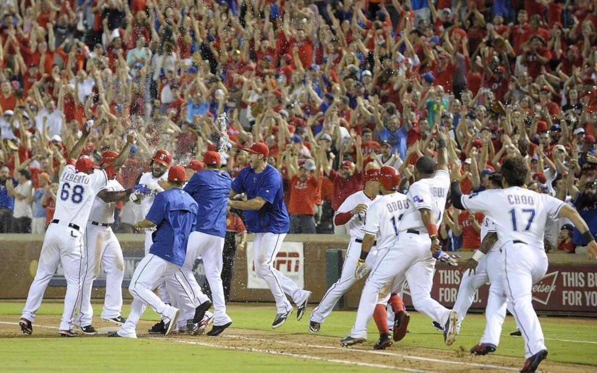 
Rangers mob first baseman Mitch Moreland after he hit a sacrifice fly to win the game in the ninth inning as the Texas beat the Houston Astros 6-5 at Globe Life Park to take over first place in the A.L. West by a half-game.
