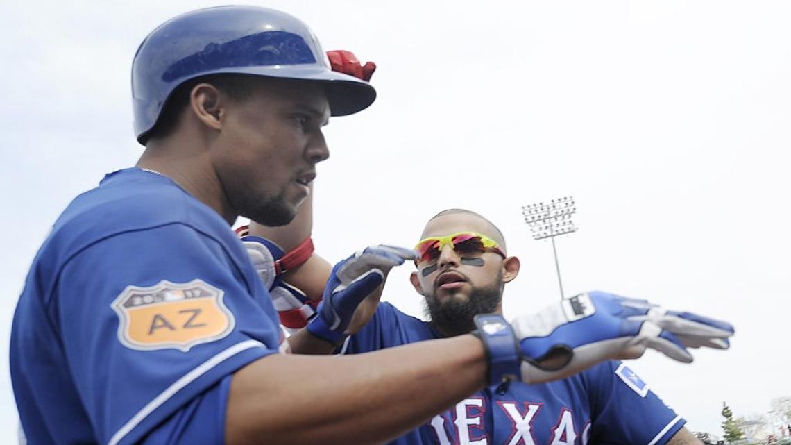 Rangers second baseman Rougned Odor congratulates center fielder Carlos Gomez after he scored a run in the first inning Friday at Surprise Stadium. The Rangers beat the Mariners 8-2 to snap a five-game losing streak.