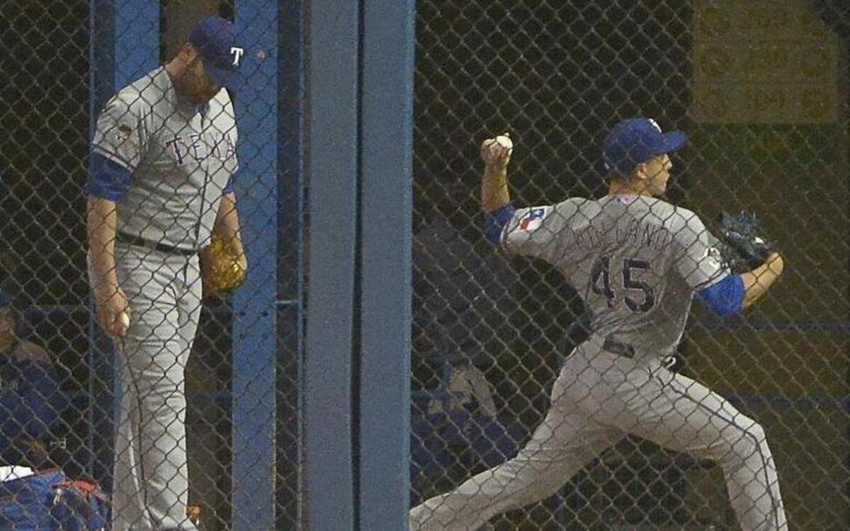 
Texas Rangers starting pitcher Colby Lewis (48) and starting pitcher Derek Holland (45) were up and pitching in the bullpen during the eighth inning as the Rangers beat the Blue Jays 6-4 in 14 innings in Game 2. Holland has won the nod over Lewis if a Game 4 is needed Monday in Arlington. 
