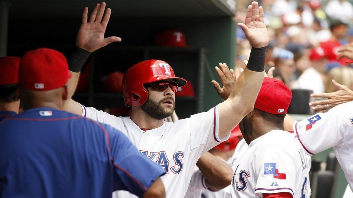 
Rangers Mitch Moreland is congratulated by teammates after scoring off of Elvis Andrus’ single in the first inning Wednesday afternoon. Moreland later hit the first of three consecutive homers in the seventh as Texas won 7-2.
