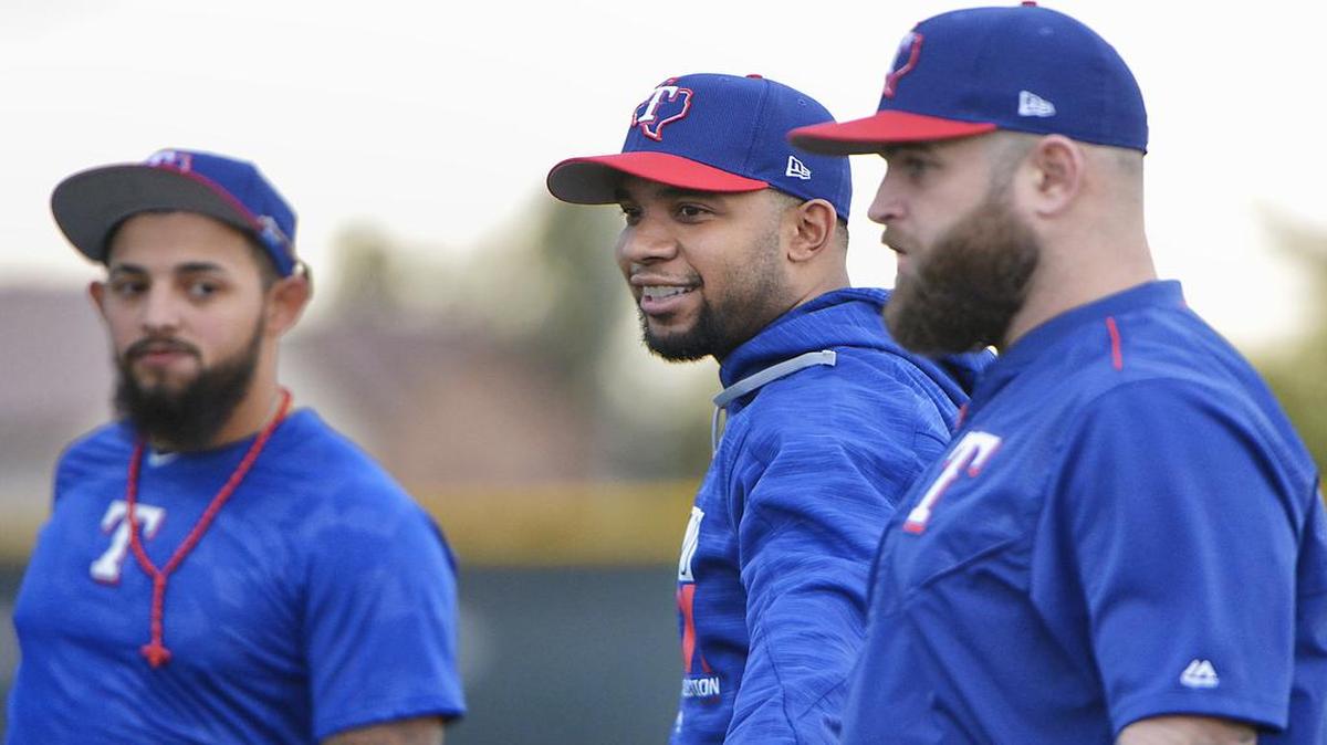 Rangers shortstop Elvis Andrus, center, second baseman Rougned Odor, left, and first baseman Mike Napoli stretch during an early spring workout in Surprise, Ariz.