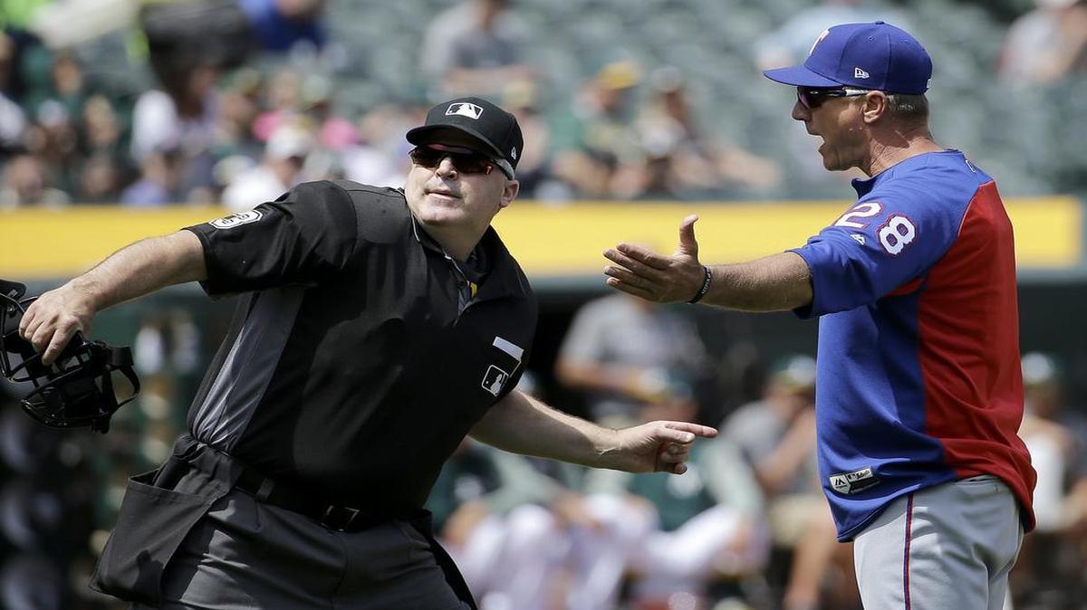 Rangers manager Jeff Banister, right, is ejected by umpire Tim Welke during the third inning Wednesday at Oakland Coliseum. Banister was arguing a ground ball ruled foul over third base. The Rangers lost to the A’s 9-1.