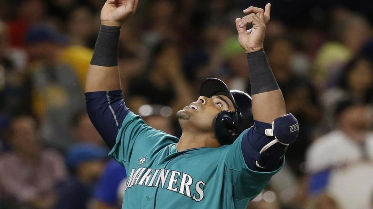 
Seattle Mariners slugger Nelson Cruz points skyward as he crosses home on his home run against the Texas Rangers in the sixth inning of a baseball game Friday, Aug. 7, 2015, in Seattle.
