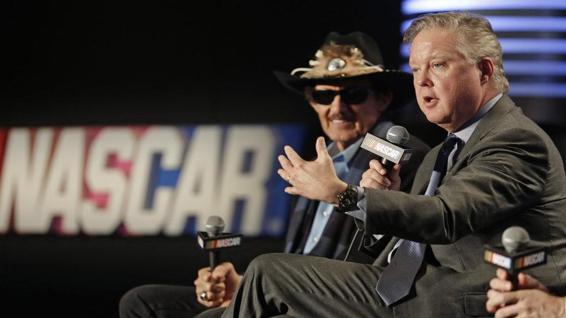 NASCAR Chairman and CEO Brian France, right, speaks as team owner Richard Petty, left, listens during a news conference Tuesday announcing a new charter system for team owners.
