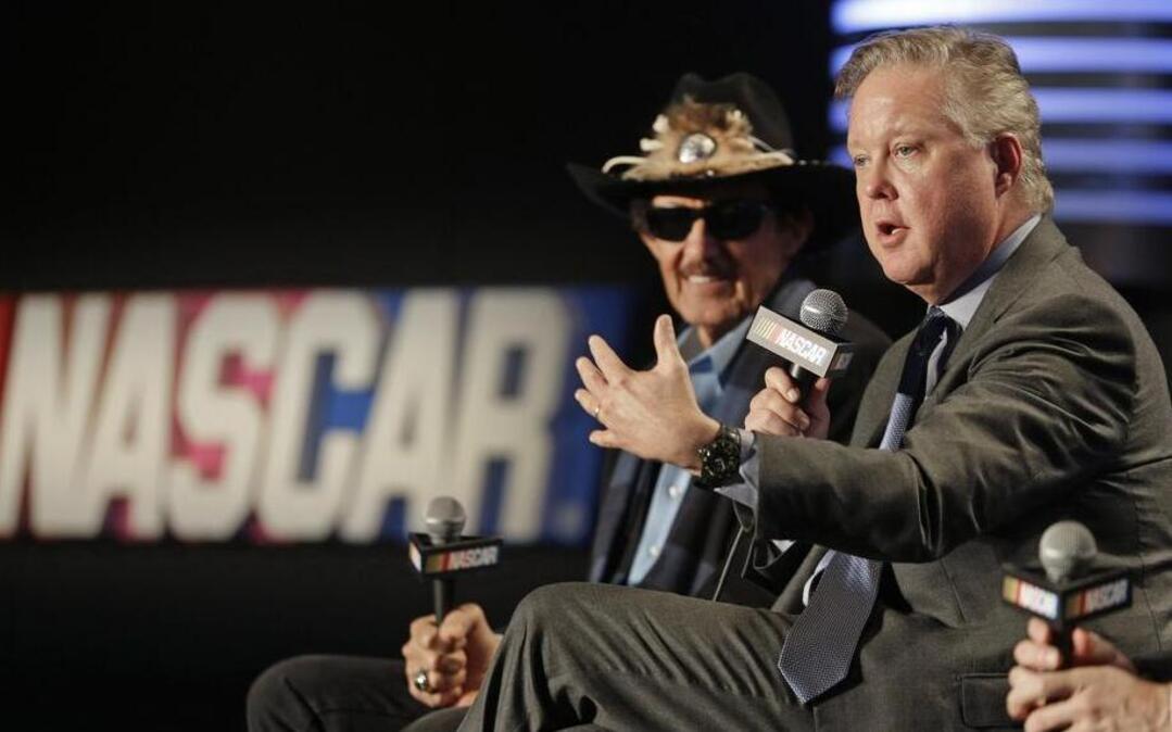 NASCAR Chairman and CEO Brian France, right, speaks as team owner Richard Petty, left, listens during a news conference Tuesday announcing a new charter system for team owners.