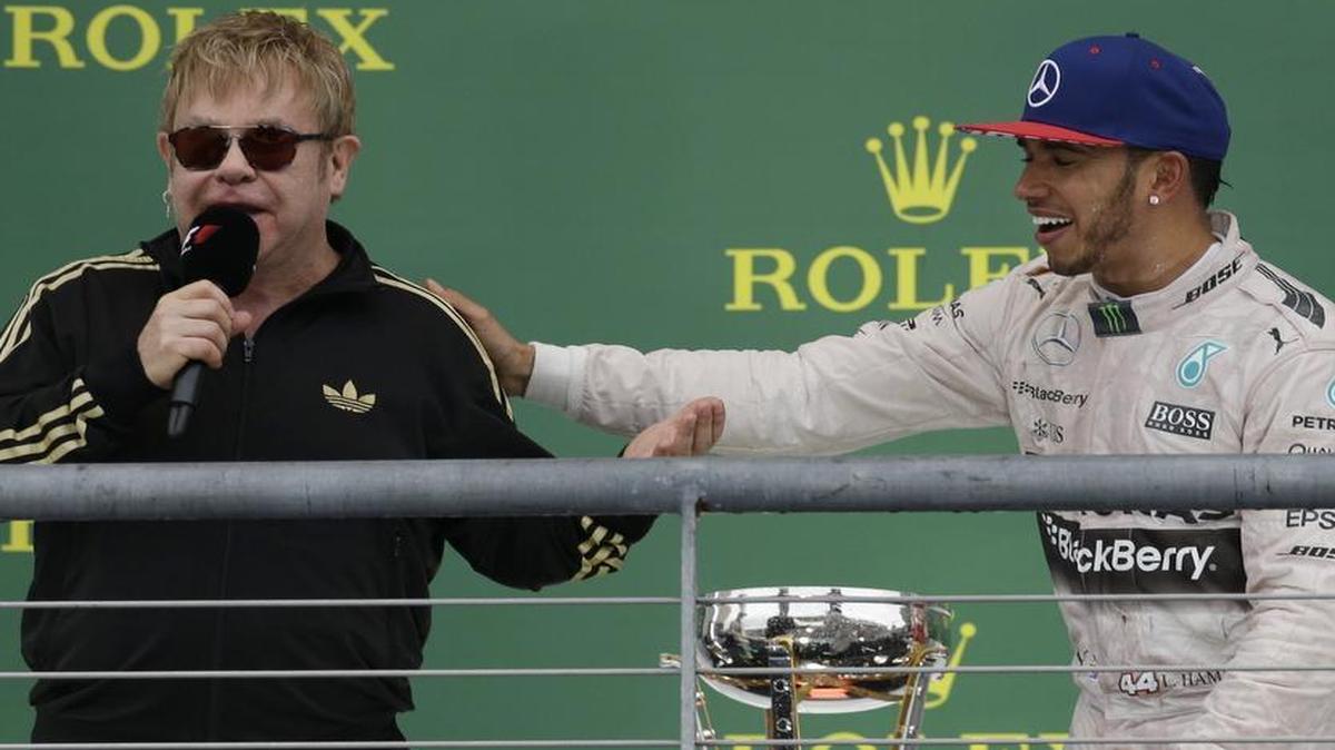 Mercedes driver Lewis Hamilton, right, of Great Britain, is interviewed by Sir Elton John after winning the world championship with his victory at the Formula One U.S. Grand Prix in Austin on Sunday.