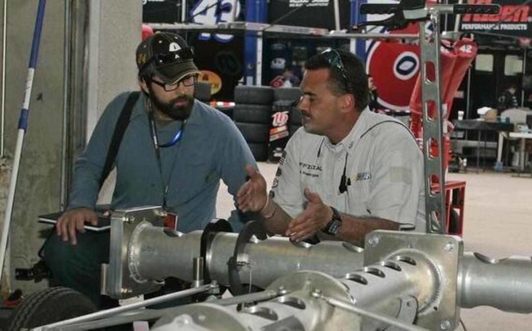 NASCAR engineer Fred Prendergast talks with scholarship recipient Jonathan Gwinn in the garage area at TMS.