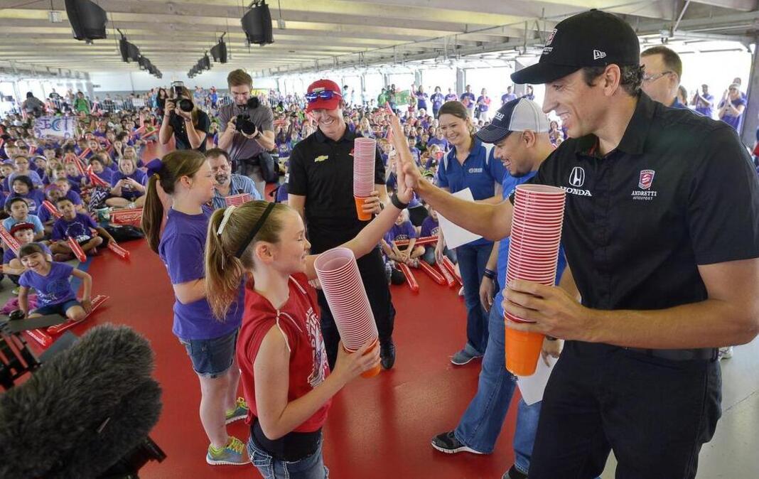 
Drivers Scott Dixon, left, and Justin Wilson, right, compete with students in a cup stacking challenge at the Speeding To Read Championship Assembly at Texas Motor Speedway in Fort Worth on Tuesday. 
