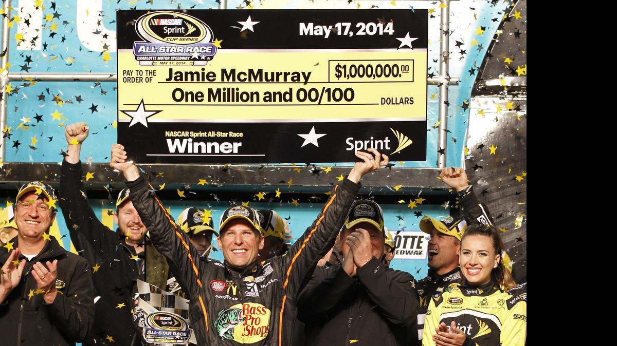 
Jamie McMurray raises the mock $1 million check in Victory Lane after winning the NASCAR Sprint All-Star race a year ago. 
